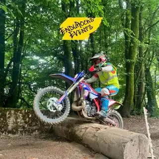 Enduro Dirt Bike Riding Over A Log In The Woods